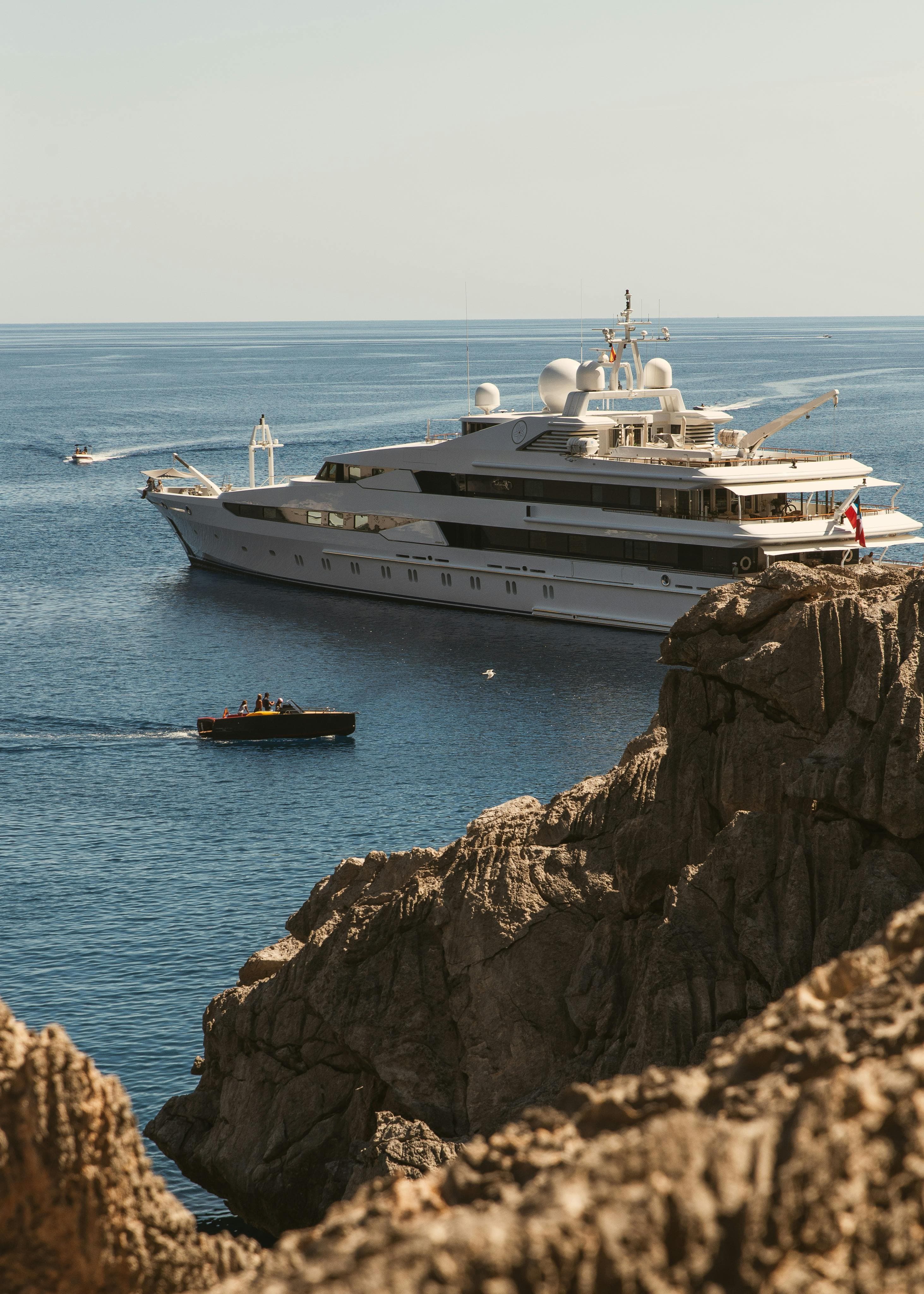 Luxury superyacht anchored near Mediterranean cliffs